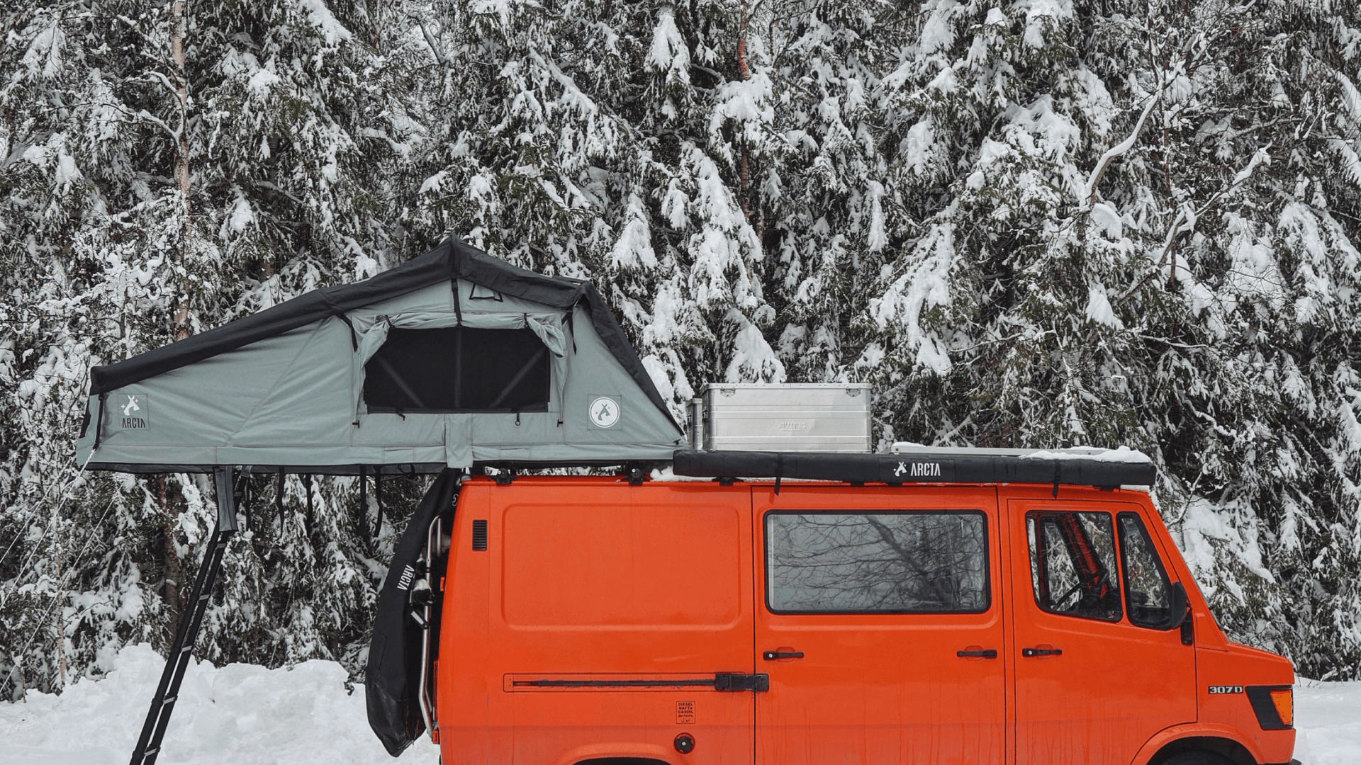 Arcta Dachzelt auf rotem Bus im Winter
