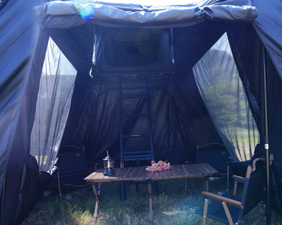 Innenansicht des Vorzelts für das NUCIS Dachzelt von ARCTA mit Tisch und Stühlen, perfekt für gemütliche Camping-Momente.